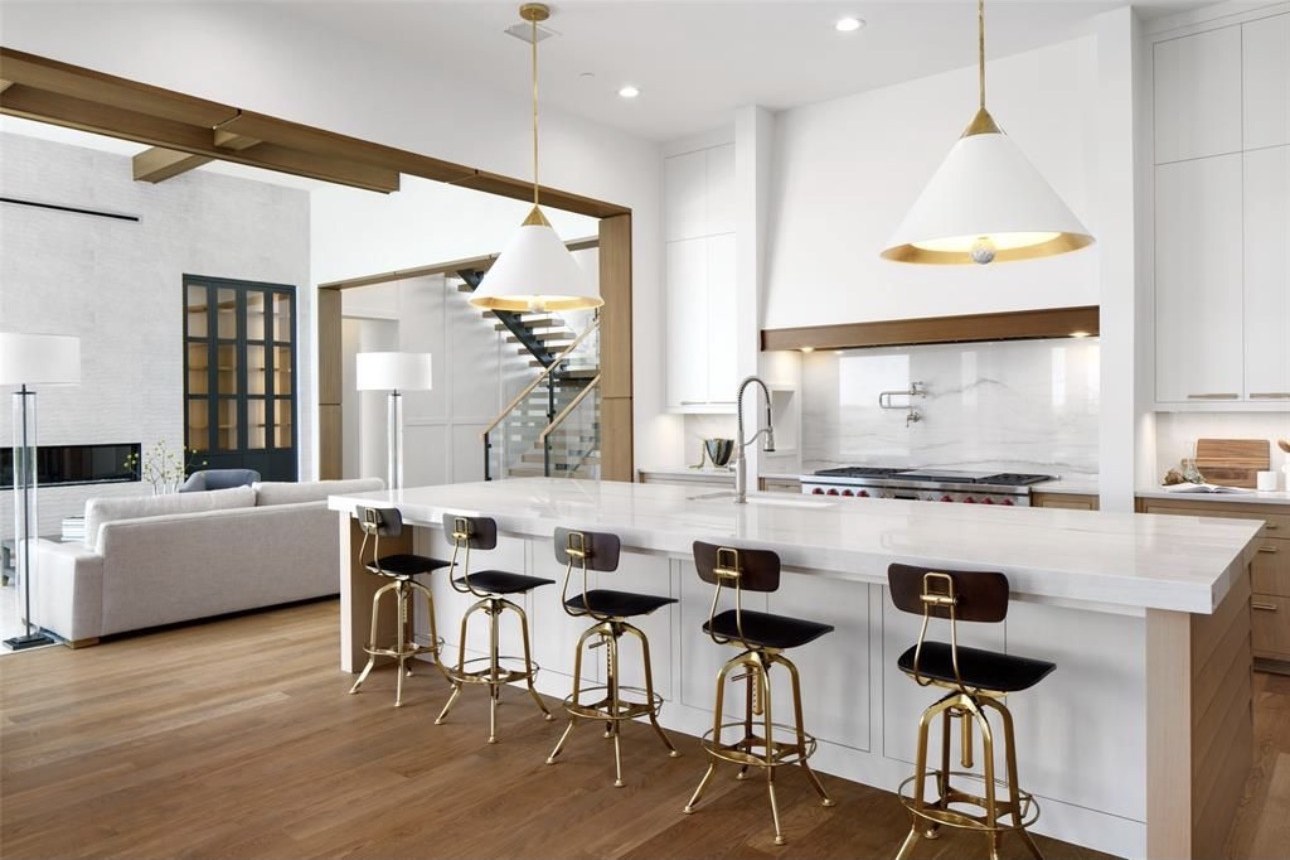 Chef's kitchen with marble island and brass pendants