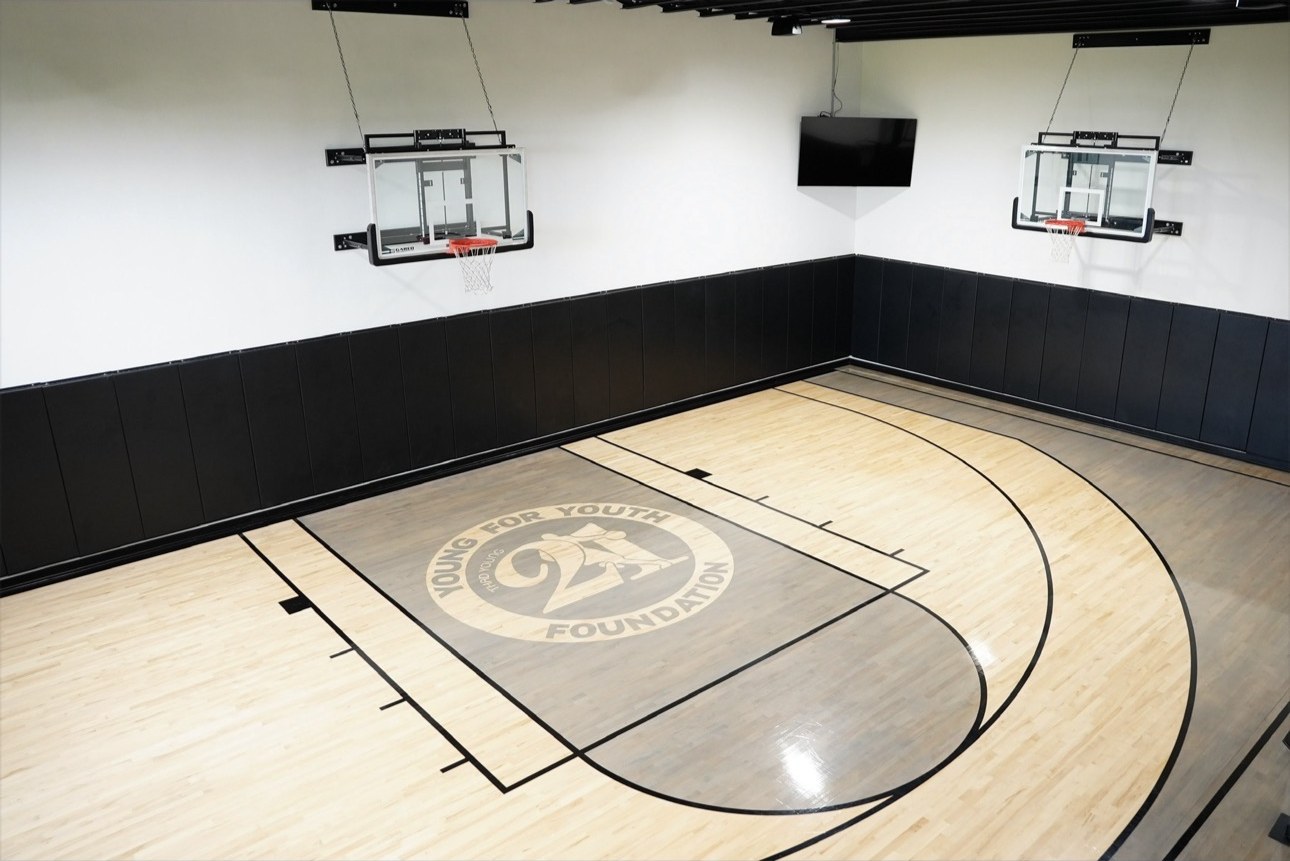 Private underground hardwood basketball court with glass backboards